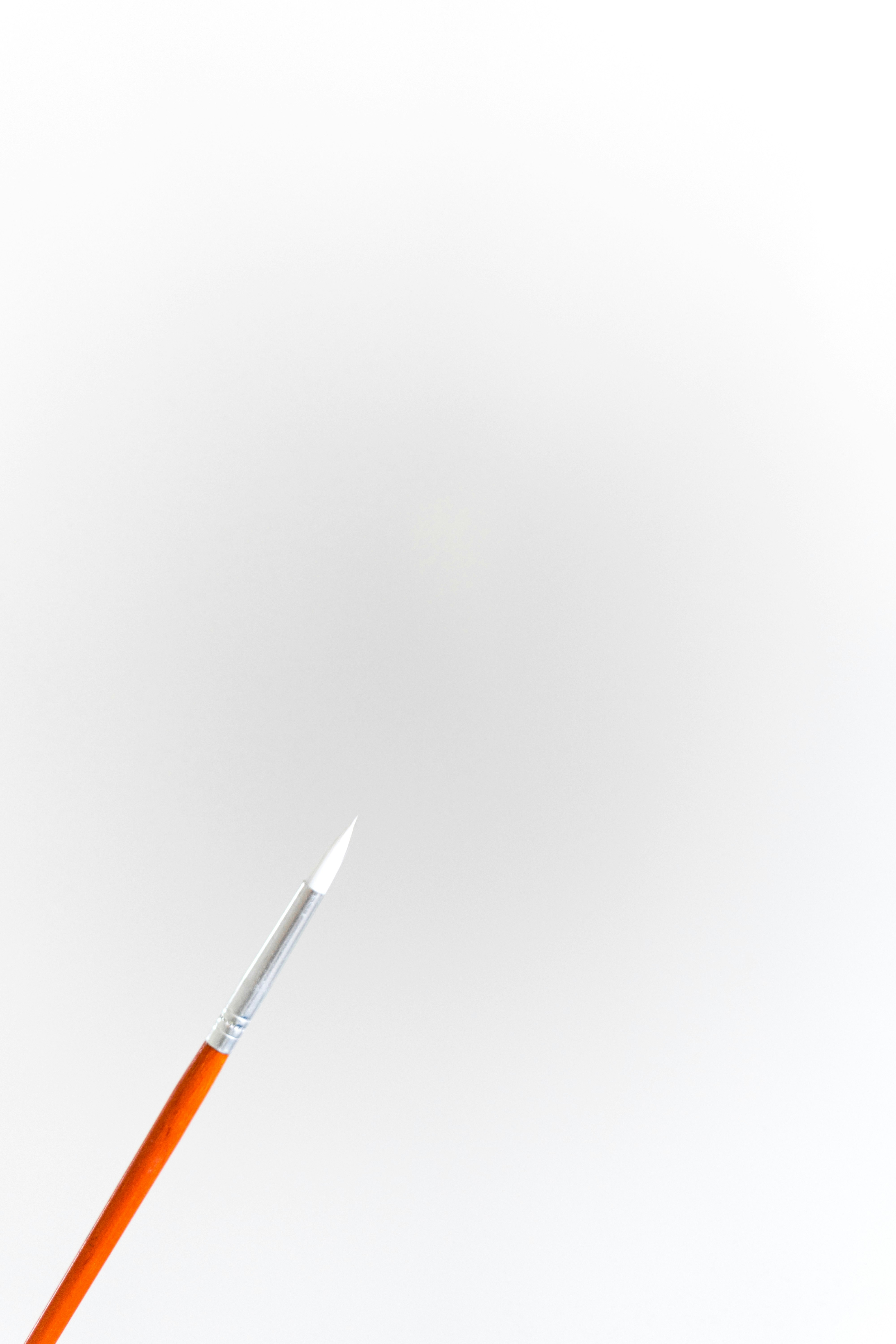 orange and white pen on white surface